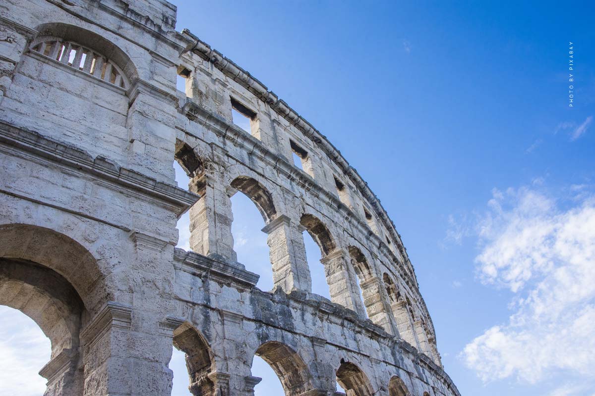 Una vista del Coliseo de Roma con el cielo azul de fondo