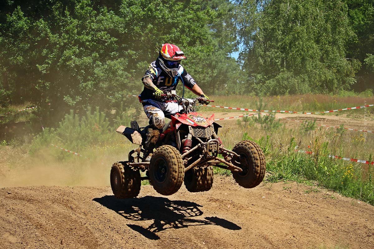 Un quadfahrer salta con su quad sobre una colina