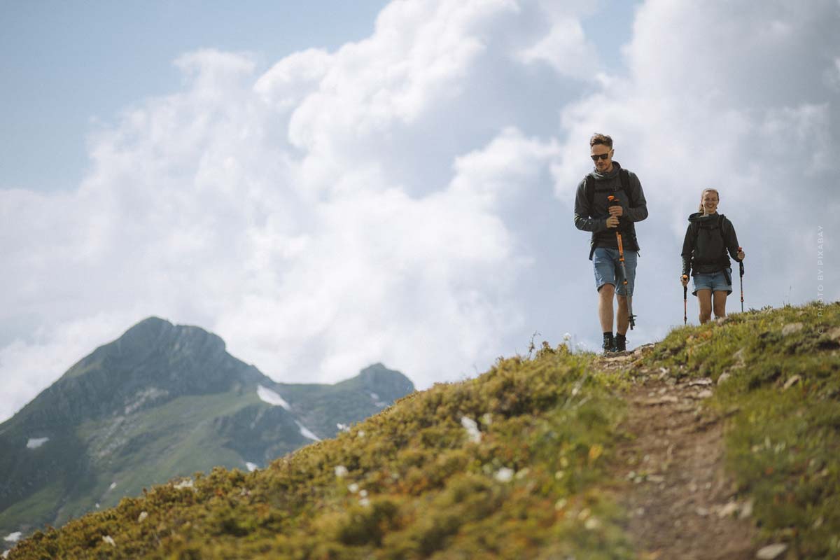 Dos personas caminan por la cima de una montaña.