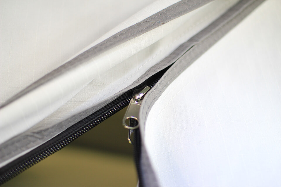 Cremalleras. Dado que las cremalleras siempre están expuestas a grandes tensiones y fuerzas, por ejemplo por el viento durante la marcha, CAMPWERK solo utiliza cremalleras extrarrobustas. Una novedad es el dobladillo de doble solapado.