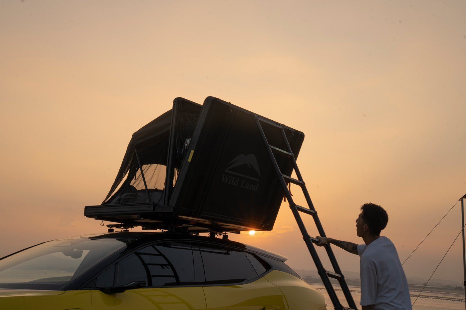 Un campista sube a su tienda de techo